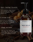Das Bergamond and Birch Body Serum Spiced Wood steht vor warmen Gewürzen während kurze Texte die intensive Pflege das weiche Hautgefühl und den dezenten warm holzigen Duft beschreiben.