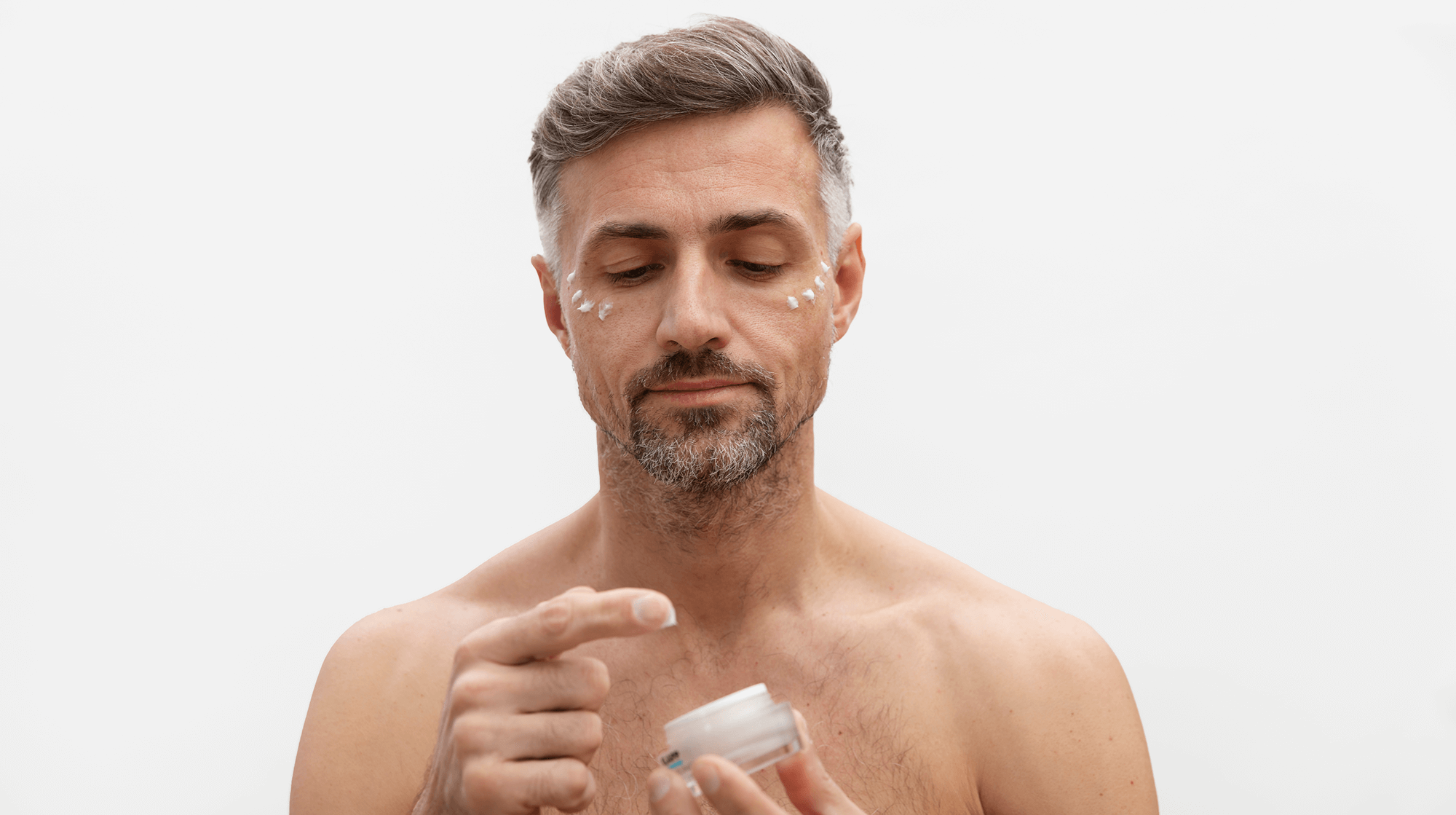 Middle-aged man applying eye cream – representing the effectiveness of anti-aging skincare routines for men by Bergamond & Birch.
