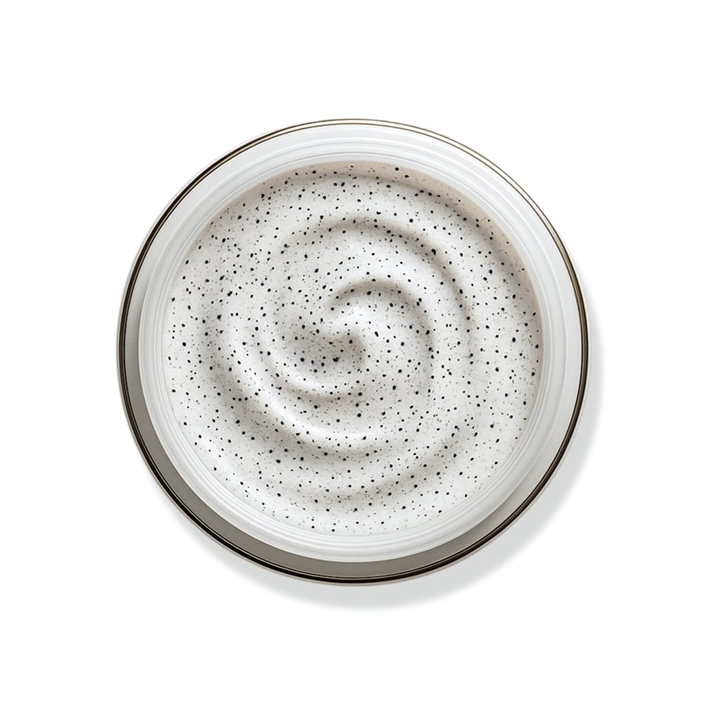 Weiße Creme mit feinen Peelingpartikeln in Wirbelstruktur für sanfte Exfoliation.