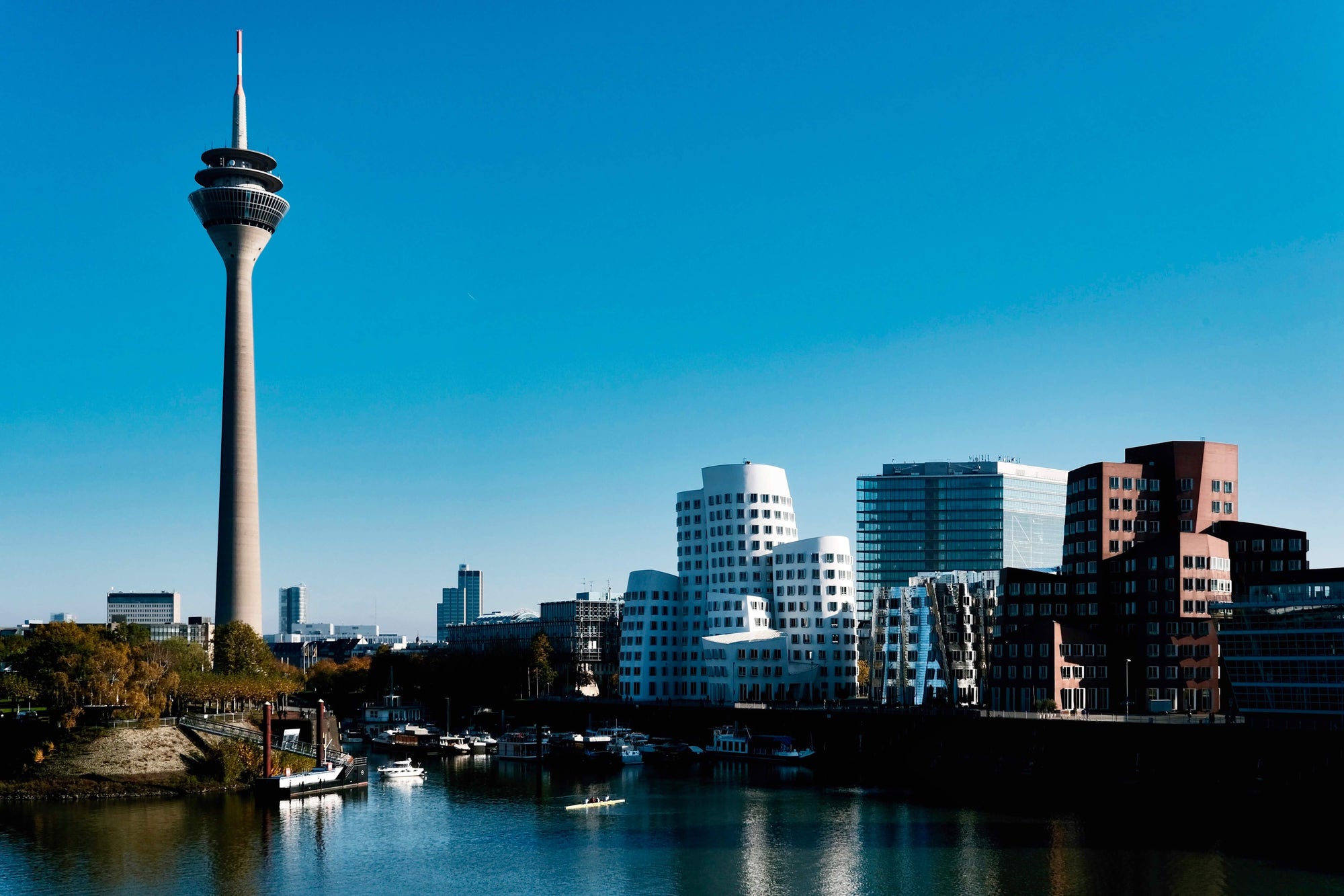 Modern skyline of Düsseldorf’s Media Harbour featuring the iconic Rheinturm (Rhine Tower) and Gehry buildings, symbolizing Bergamond & Birch’s urban roots and design-forward identity